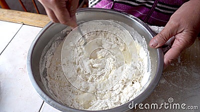 Mixing the dough in a metal bowl Stock Photo
