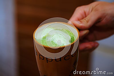 Mixing Green Barley Grass Powder in man hand. Juice for Vitality Stock Photo