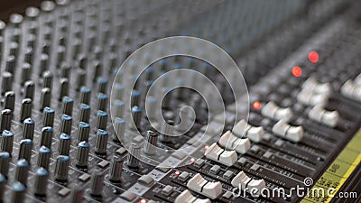 Mixing table with buttons and volume controls and red lights. Music and radio studio Stock Photo