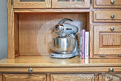 Mixmaster blender with cookbooks on shelf of oak sideboard Editorial Stock Photo