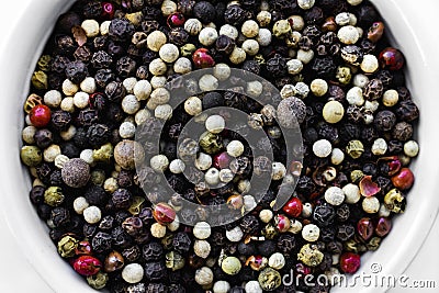 A mixture of pepper varieties with peas on the white plate on the white background. Heap of various pepper. Mix of red Stock Photo