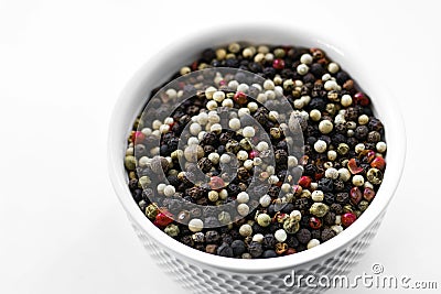 A mixture of pepper varieties with peas on the white plate on the white background. Heap of various pepper. Mix of red Stock Photo