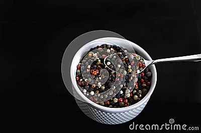 A mixture of pepper varieties with peas on the white plate on the black background. Heap of various pepper. Mix of red Stock Photo