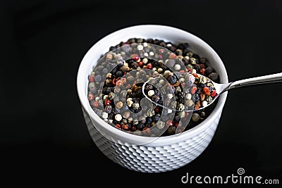 A mixture of pepper varieties with peas on the white plate on the black background. Heap of various pepper. Mix of red Stock Photo