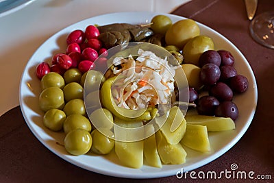 Mixtured acids in the plate. Plum pickle , loaf, cucumber, pepper, cabbage, eggplant, cranberry Stock Photo