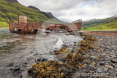 Mjoifjordur, Iceland - Abandoned fishing boat rusts in fjord Stock Photo
