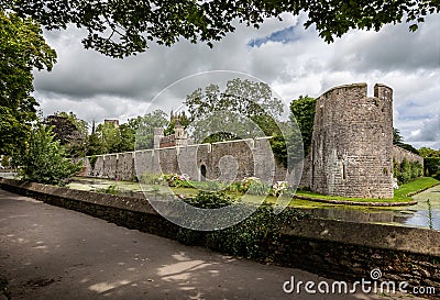 Moat and turreted walls surrounding the Bishops Palace in Wells, Somerset, UK Stock Photo