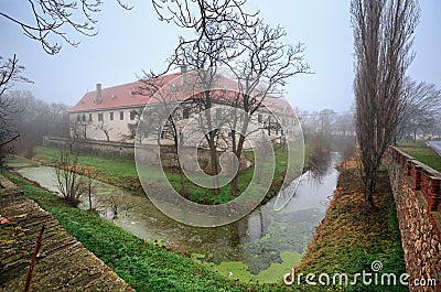The moated manor house in the market town of Guntersdorf on a foggy winter day. Lower Austria. Stock Photo
