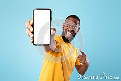 Mobile app advertisement. Excited black man pointing at smartphone with empty screen, mockup. Space for ad or website Stock Photo