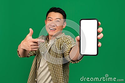 Mobile app advertisement. Happy asian mature man pointing at empty smartphone screen, mockup Stock Photo
