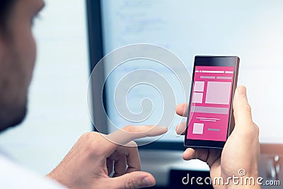 Mobile application development - programmer with smartphone Stock Photo