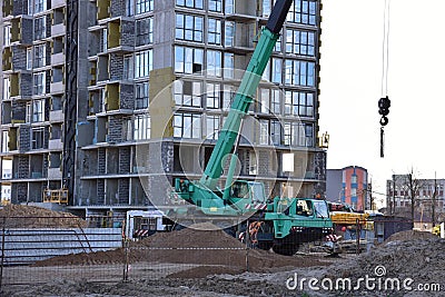 Mobile auto crane at construction site. Work of truck crane on project works. Tower cranes and builders in action. Crane for Stock Photo