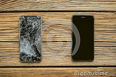 Mobile phone with broken touchscreen on wooden background Stock Photo