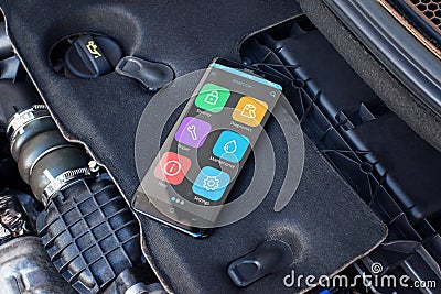 Mobile phone on a car engine with apps for diagnosing car problems Stock Photo