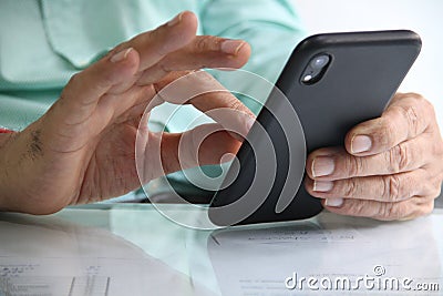 Mobile phone in hands working in office table Stock Photo