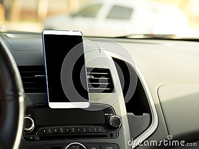 Mobile phone located in the center of the vehicle console. Black screen phone in the car Stock Photo