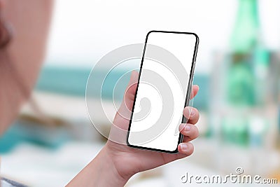 Mobile phone mockup in woman hand. View above shoulder Stock Photo