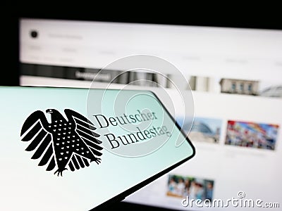 Mobile phone with seal of German federal parliament Bundestag on screen in front of website. Editorial Stock Photo