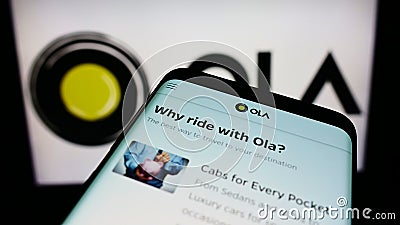 Mobile phone with webpage of Indian ridesharing company Ola Cabs on screen in front of business logo. Editorial Stock Photo