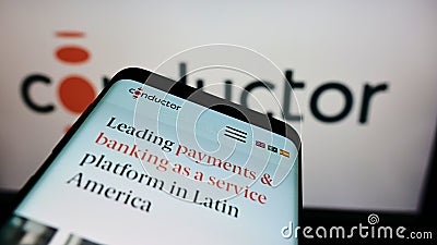 Mobile phone with website of Brazilian payment company Conductor Technology Ltd. on screen in front of logo. Editorial Stock Photo