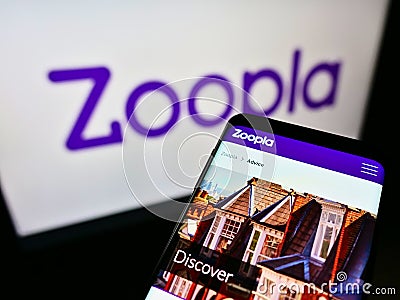 Mobile phone with website of British real estate platform Zoopla Limited on screen in front of business logo. Editorial Stock Photo