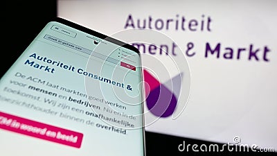 Mobile phone with website of Dutch regulator Autoriteit Consument en Markt (ACM) on screen in front of logo. Editorial Stock Photo