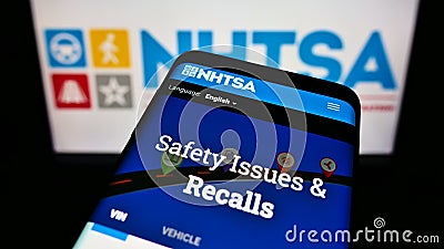 Mobile phone with website of National Highway Traffic Safety Administration (NHTSA) on screen in front of logo. Editorial Stock Photo