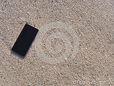 Mobile smart phone on the sandy beach with soft waves of sea background. Internet of thing concept. Stock Photo