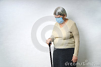 Mobility problems in old age concept. Sad old woman holds a walking stick Stock Photo