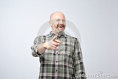 Mock or bad joke concept. Mature man pointing finger and toothy smile. Stock Photo