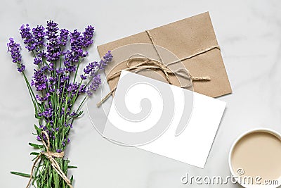 Mock up blank greeting card and envelope with lavender flowers and cup of cappuccino with copy space. top view Stock Photo
