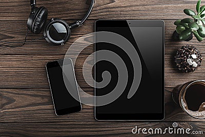 Mock-up blank screen tablet and smartphone, office desk table with headphones, biscuits and coffee cup. Top view Stock Photo