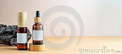 A mock-up of a brown cosmetics bottles with dispenser and white label and dropper bottle with pipette on wooden podium for Stock Photo