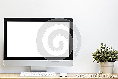 A mock up computer device on a table with white wall. Stock Photo