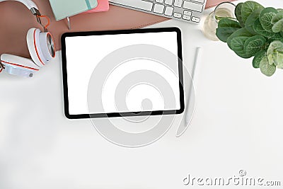 Digital tablet, stylus pen, houseplant and headphone on white table. Stock Photo