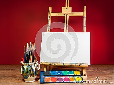 Mock up easel palette watercolors and brushes with empty white canvas Stock Photo