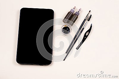 Mock up empty black tablet screen near a set for brow hena, tweezing procedure. Video tutorial, online fashion workshop Stock Photo
