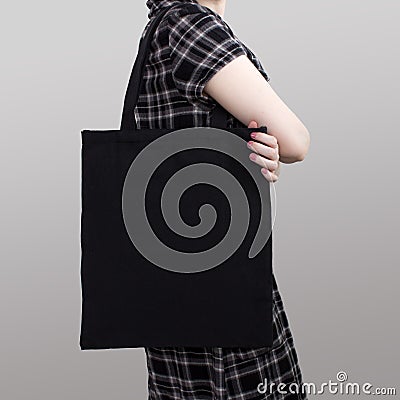 Mock-up. Girl in dress carries black cotton tote bag. Stock Photo