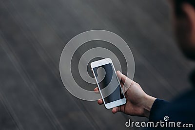 Mock up of man hold phone in right hand. Background of wooden floor Stock Photo