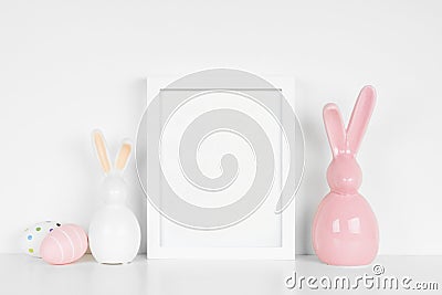 Mock up portrait white frame with Easter Eggs and modern glass bunny decor Stock Photo