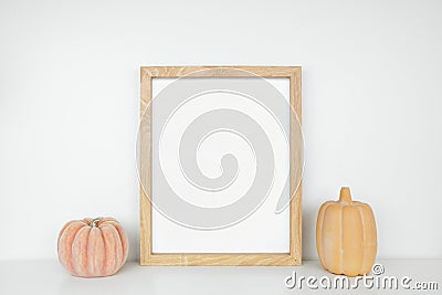 Mock up portrait wooden frame with autumn pumpkin decor on a white shelf Stock Photo