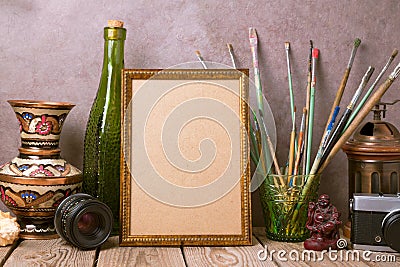 Mock up poster frame with vintage artistic objects and old camera on wooden table Stock Photo