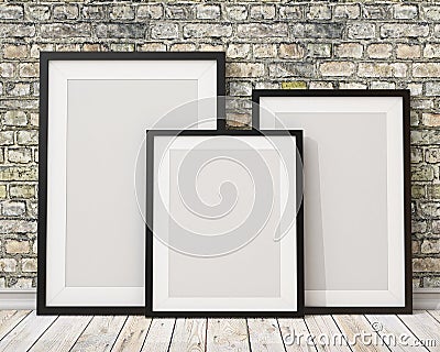 Mock up three blank black picture frames on the old brick wall and the wooden floor, background Stock Photo