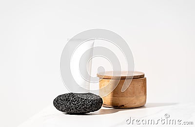 Mock up white cosmetics tube on black volcanic pumice lying on bathroom table. Stock Photo