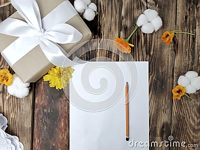 Mockup autumn flatlay composition with gift box, flowers, empty card on wooden table. Stock Photo