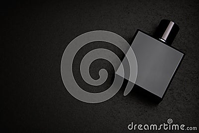 Mockup of black fragrance perfume bottle mockup on dark empty background. Top view. Horizontal. Stock Photo