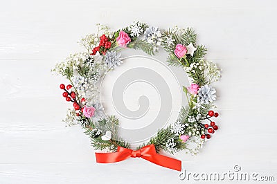 Mockup of Christmas Wreath Made of Naturalistic Looking Pine Branches Decorated with Red Berries. Flat lay on a white wooden backg Stock Photo