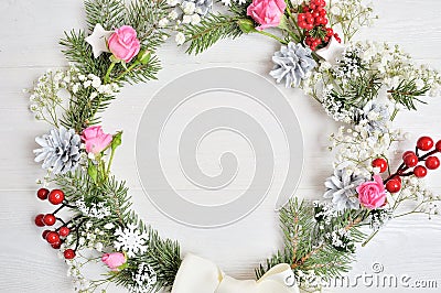 Mockup of Christmas Wreath Made of Naturalistic Looking Pine Branches Decorated with Red Berries and roses. Flat lay on a white wo Stock Photo