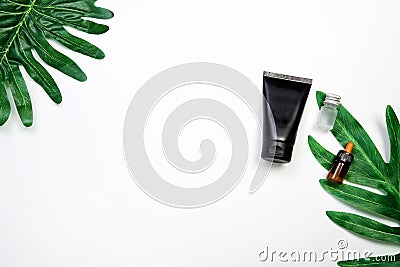 Mockup of cosmetic black cream bottle, Blank label package on a green leaves background. Stock Photo