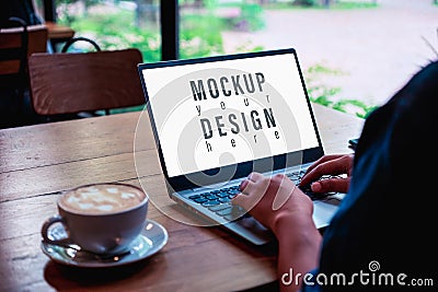 Mockup image of a business woman using and typing on laptop computer keyboard with blank white desktop screen with coffee latte Stock Photo